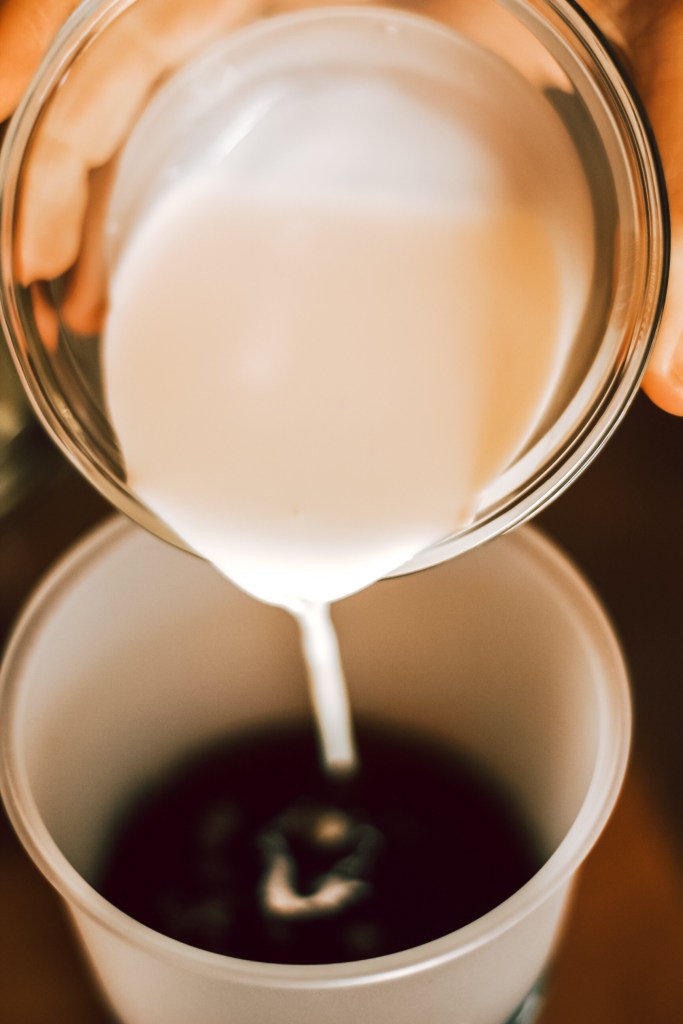 Cream pouring into coffee