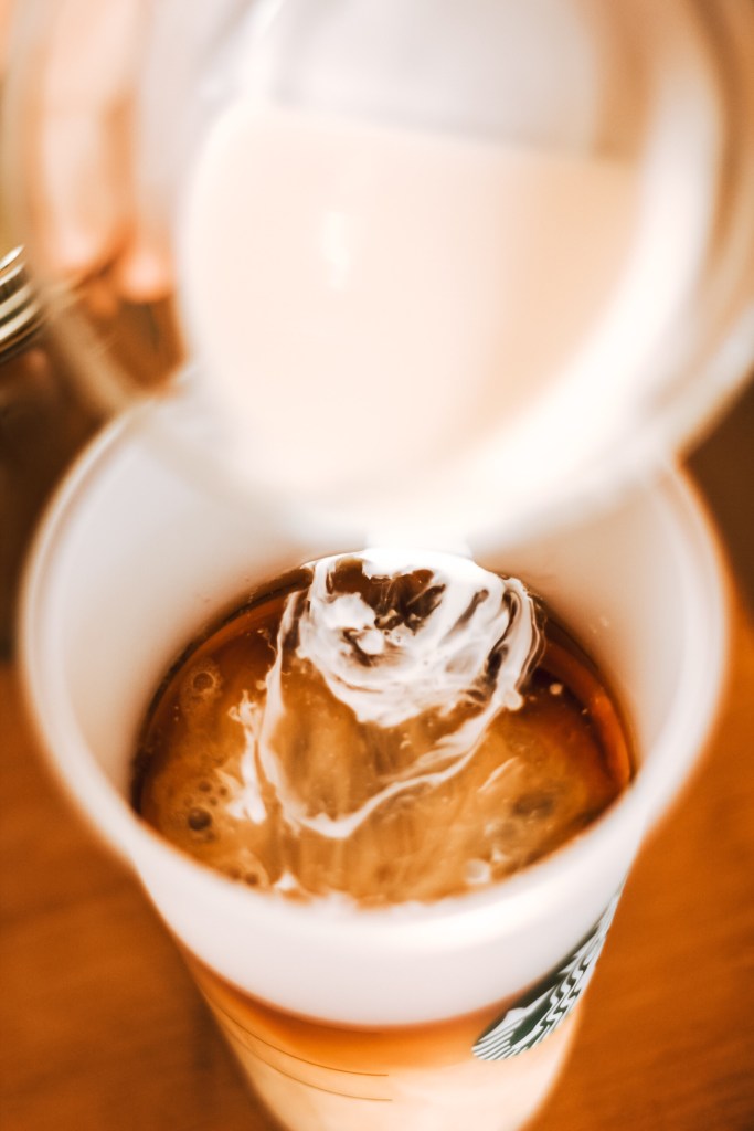 Cream pouring into coffee