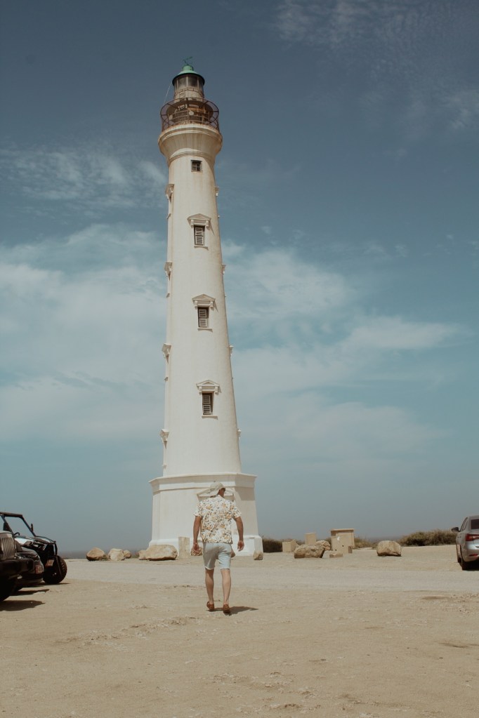 man walking to california lighthouse in aruba
