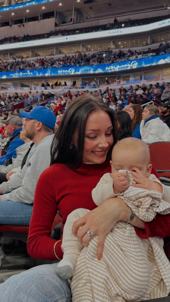 woman holding baby in united center arena in chicago at sport event